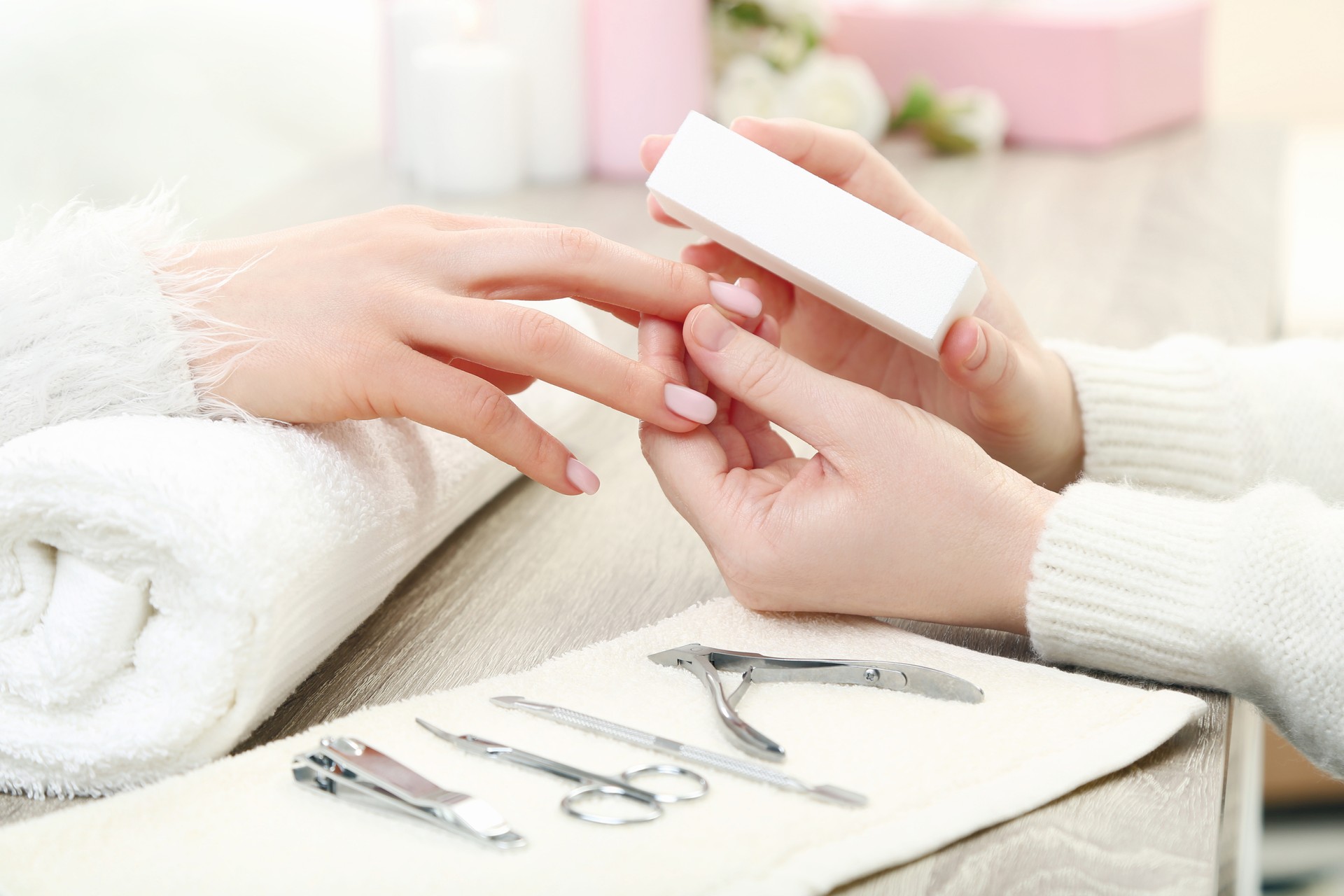 Manicurist making manicure for client by nail file